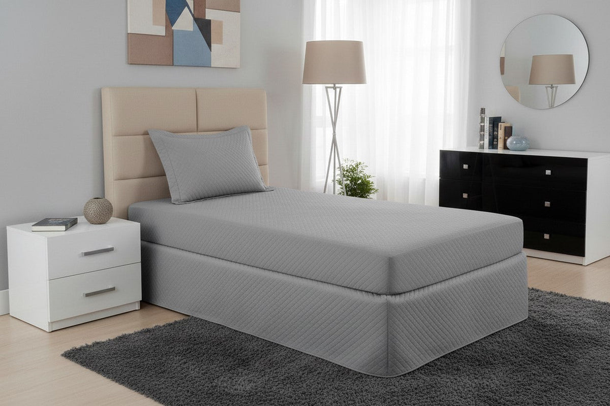 Gray waterproof quilted single mattress protector by Maison Charlo, with soft bedding fabric and secure fitted edges.